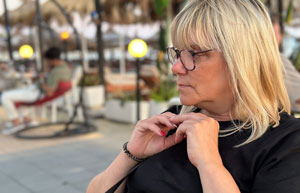 woman sitting outdoors with glasses and long blonde hair