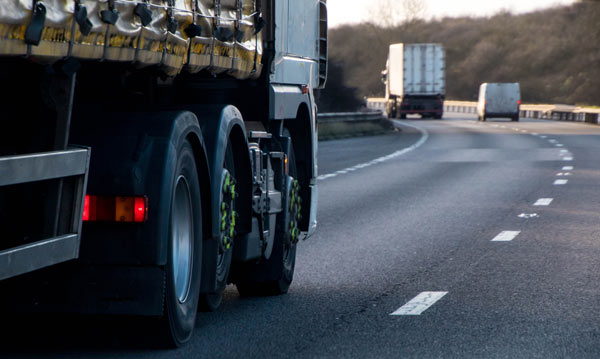 view of a truck on a highway with another truck in the distance